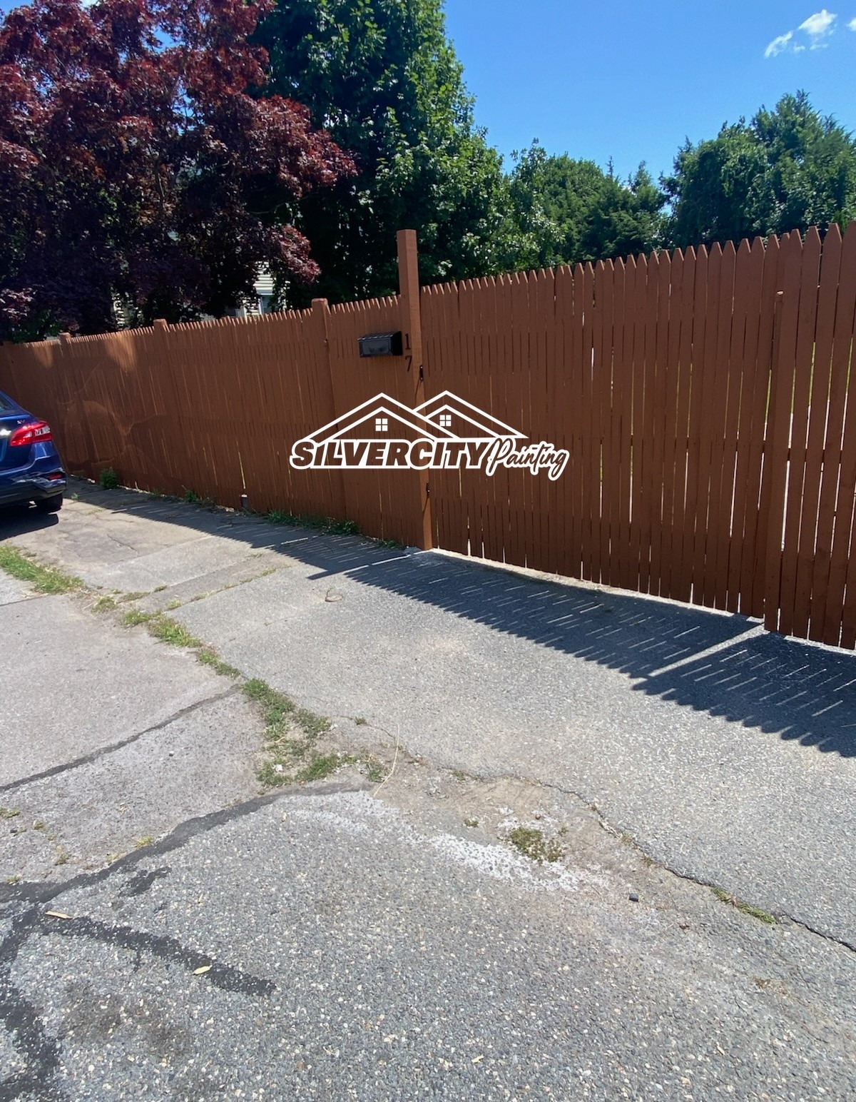 After staining — stockade fence coated in rich brown solid stain in Taunton, MA