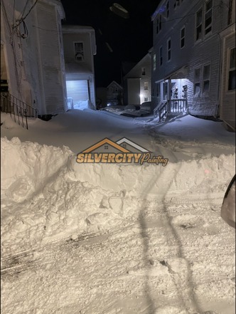 Before snow clearing — deep snow blocking an alley and driveway between homes