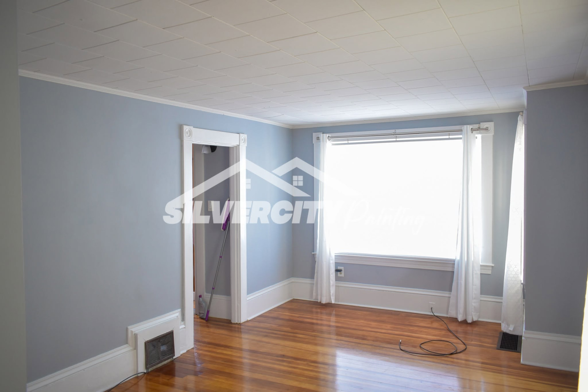 Bedroom painted in soft blue-grey with white crown molding, baseboards and a white tile ceiling in Taunton, MA