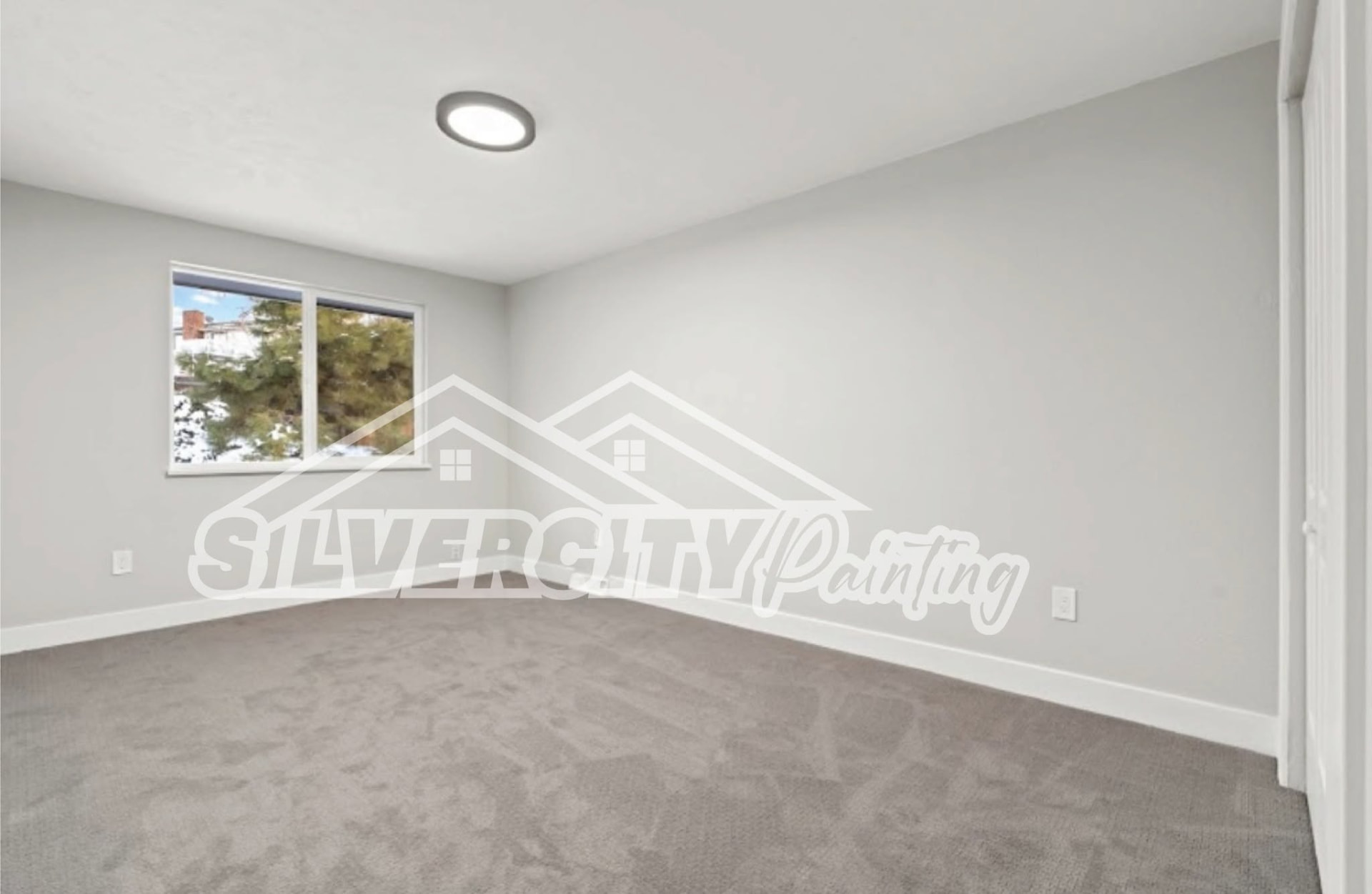 Empty bedroom with smooth light grey painted walls and white baseboards
