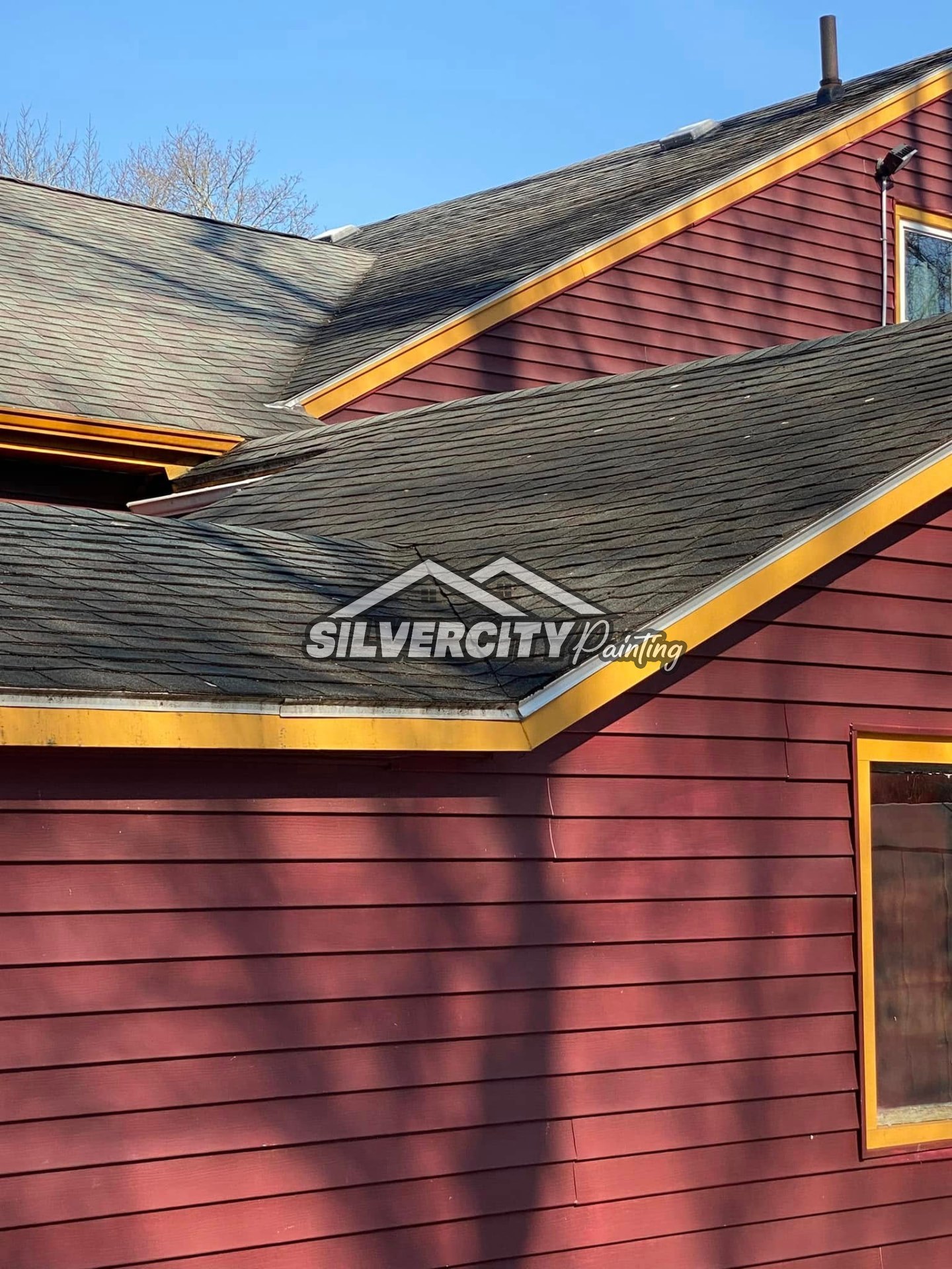 Red clapboard siding and shingled roof cleaned by soft wash exterior cleaning in Taunton, Massachusetts