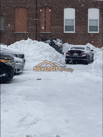 Before snow clearing — vehicles surrounded by heavy snowfall in a parking area